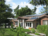 house with solar panels and vegetable garden